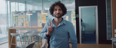 a man in a blue shirt holding a knife and fork