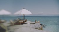 a woman sitting on a dock next to the ocean