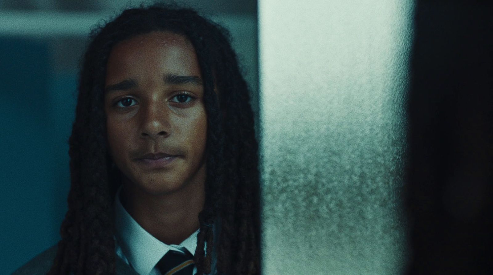 a man with long hair wearing a tie