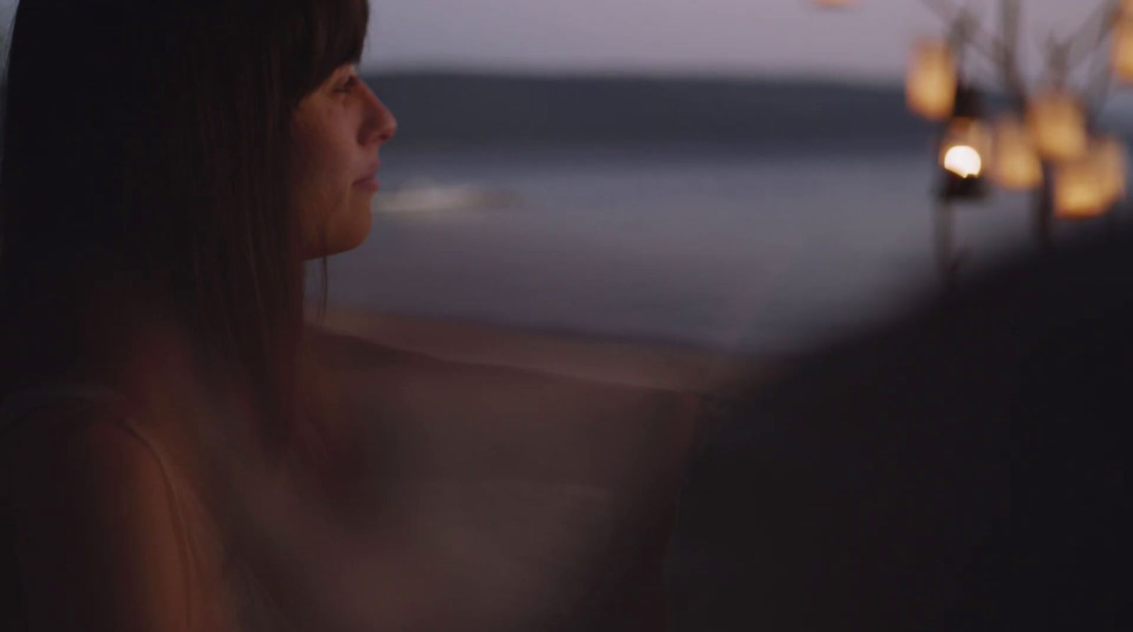 a woman standing in front of a window at night