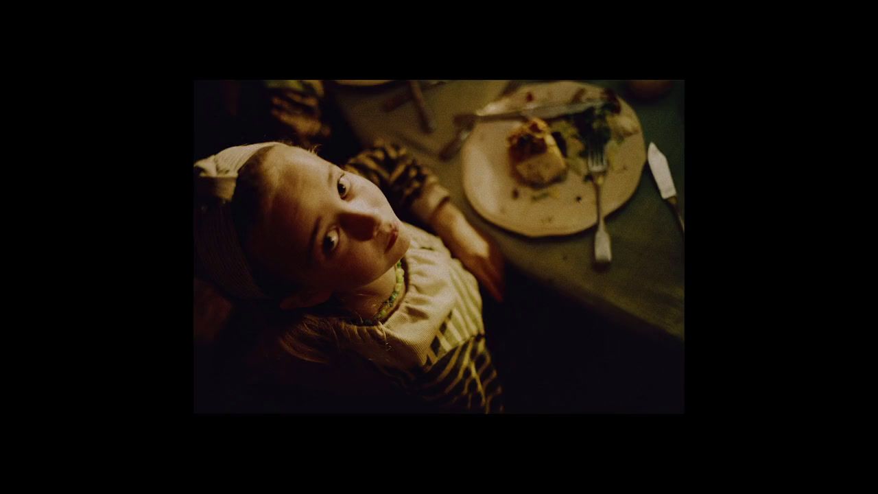 a baby laying on a table next to a plate of food