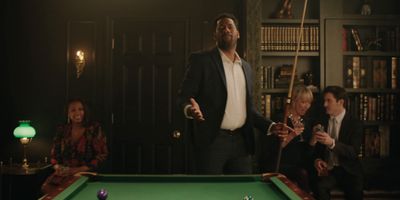 a man standing next to a pool table