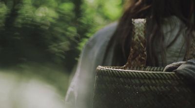 a woman carrying a basket in a forest