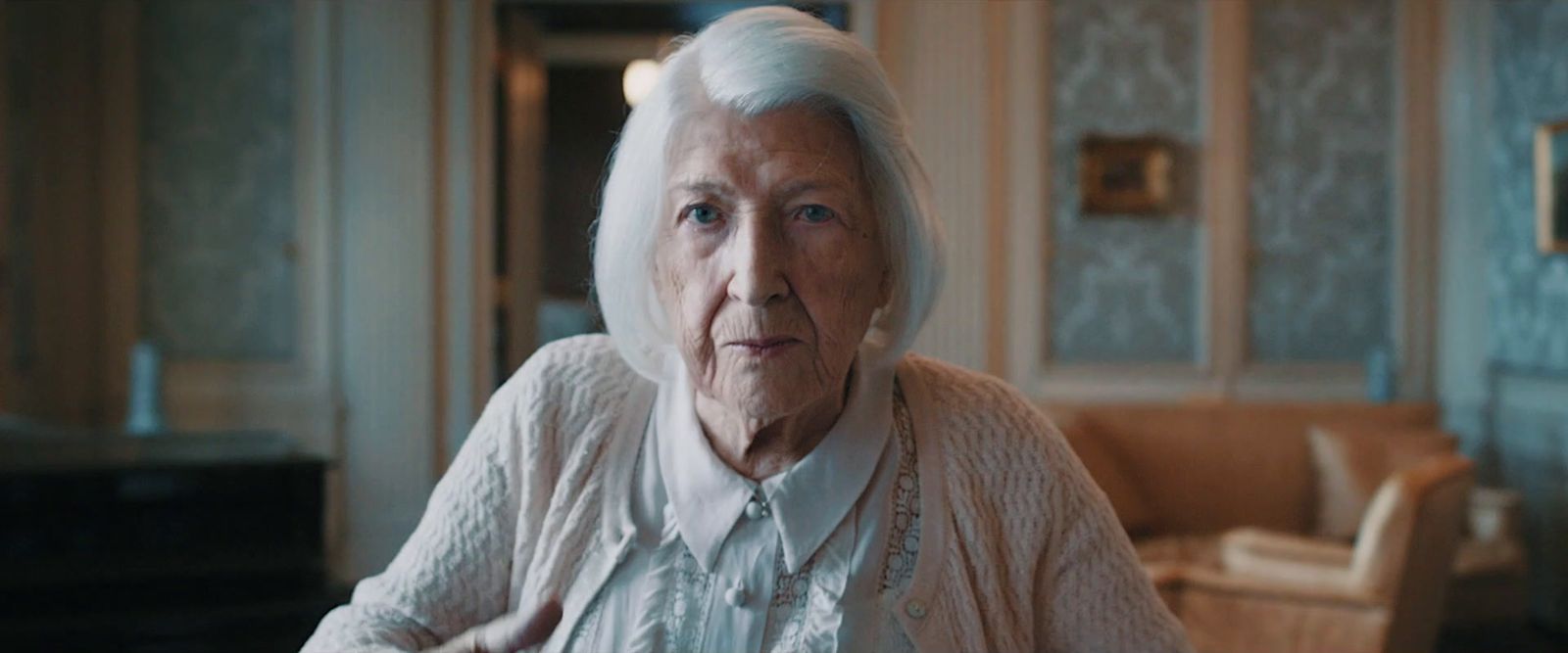 an old woman sitting in a chair in a room