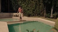 a man standing in a pool with a suitcase