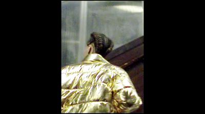 a woman in a shiny gold jacket on a cell phone