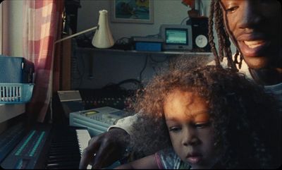 a man and a little girl playing a piano