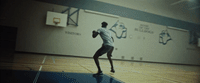 a man in a white shirt is playing a game of basketball