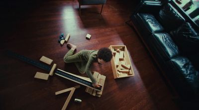 a young boy playing with wooden blocks on the floor