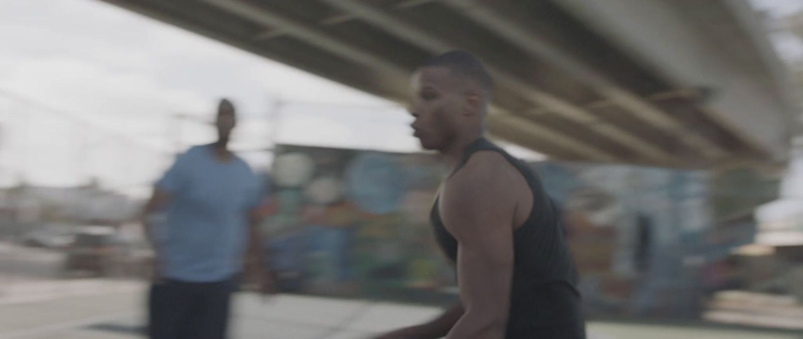 a blurry image of two men walking under a bridge