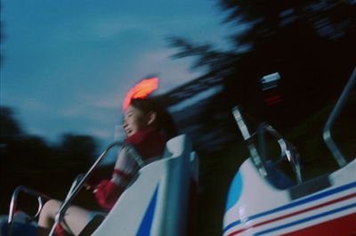 a young boy riding a roller coaster at a carnival