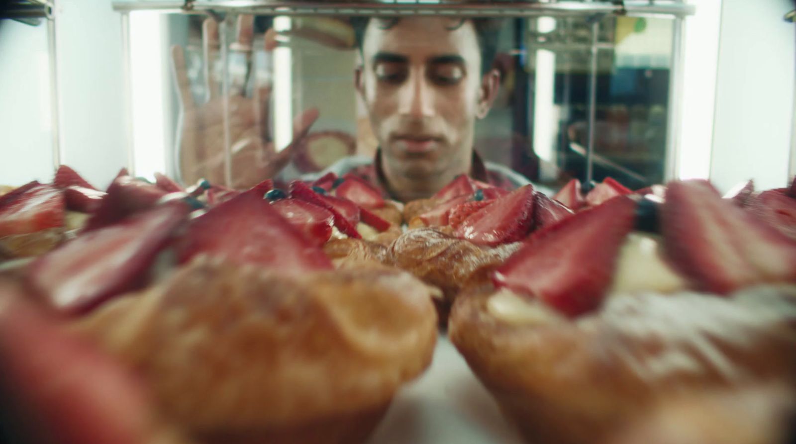 a man taking a picture of a bunch of pastries