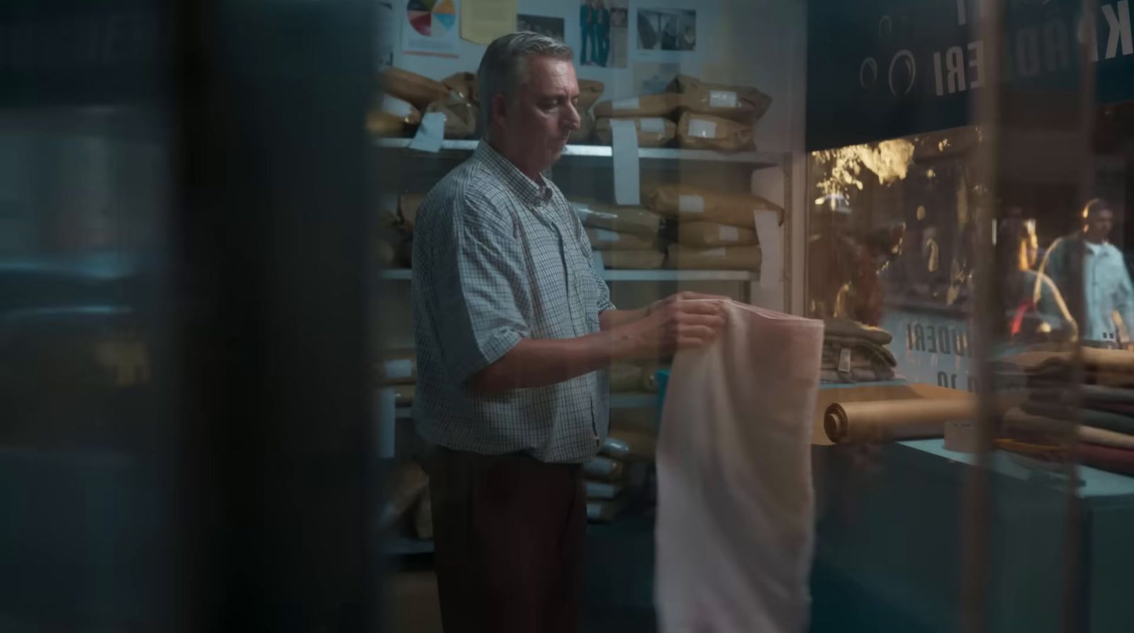 a man standing in front of a bakery holding a bag of bread