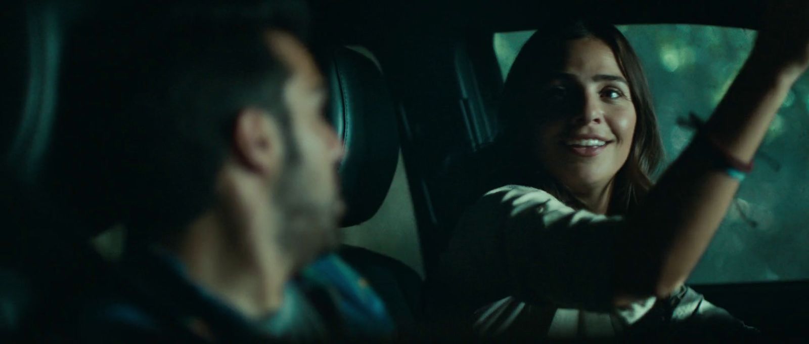 a woman sitting in a car with a man behind her