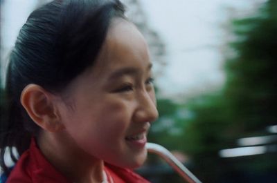 a young woman smiles while holding an umbrella