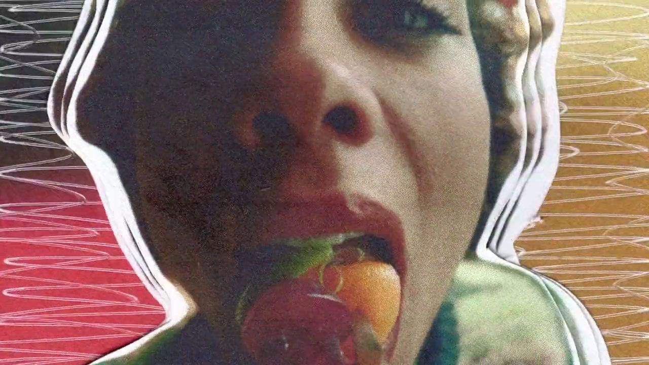 a woman eating a piece of fruit in front of her face