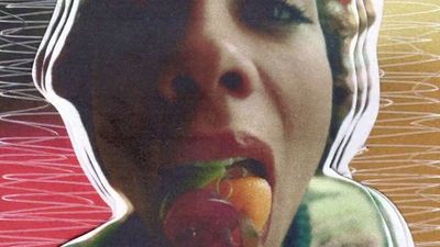 a woman eating a piece of fruit in front of her face