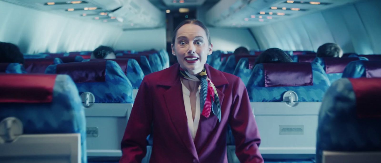 a man in a suit and tie standing on an airplane