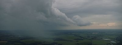 a large cloud is in the sky over a green field