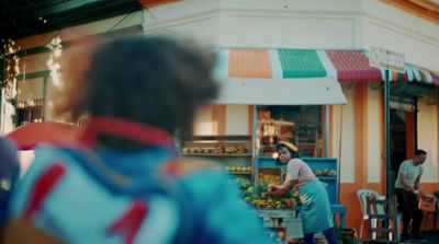 a woman standing in front of a fruit stand