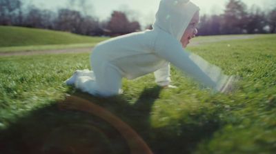 a person in a white suit playing in the grass