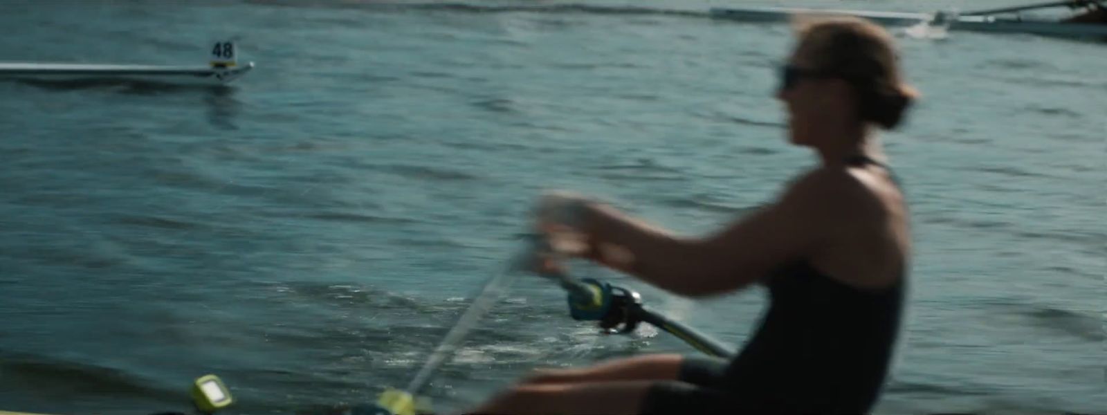 a woman rowing a boat on a body of water