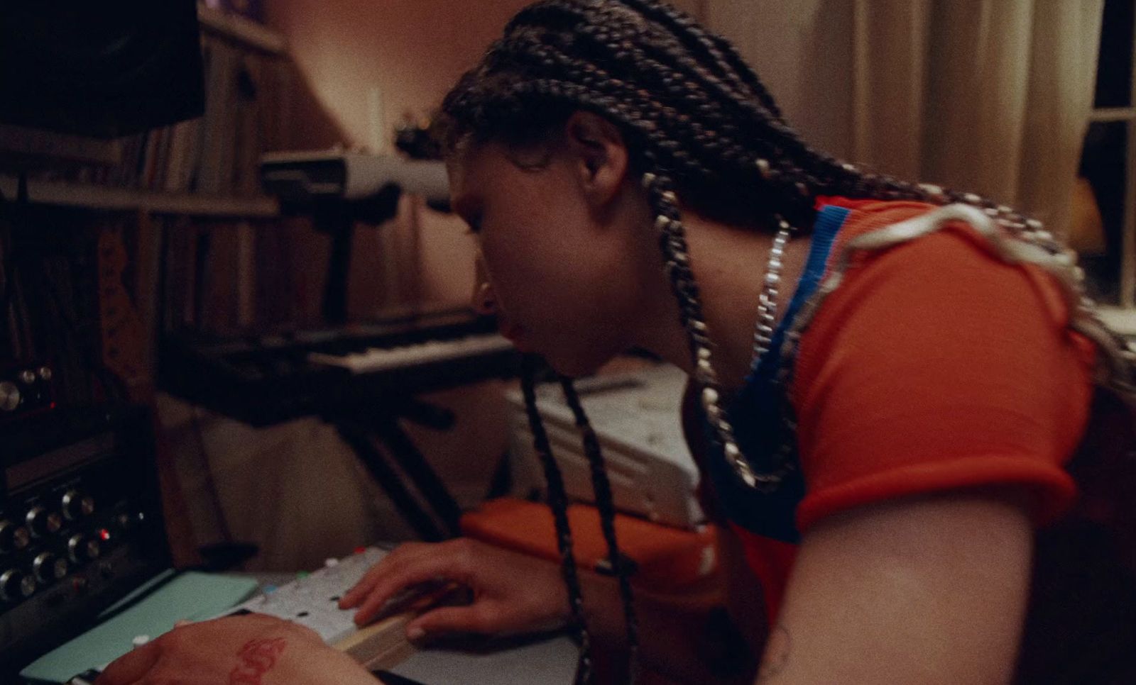 a woman with dreadlocks is writing on a piece of paper