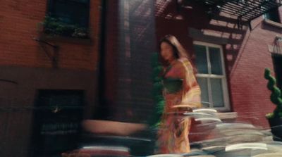 a woman walking past a tall brick building