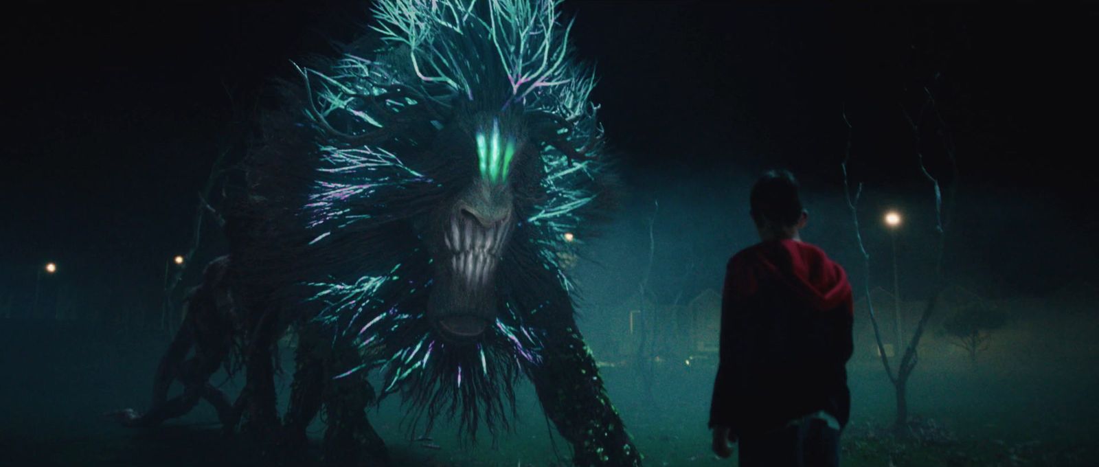 a man standing next to a giant creature in the dark