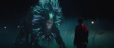 a man standing next to a giant creature in the dark