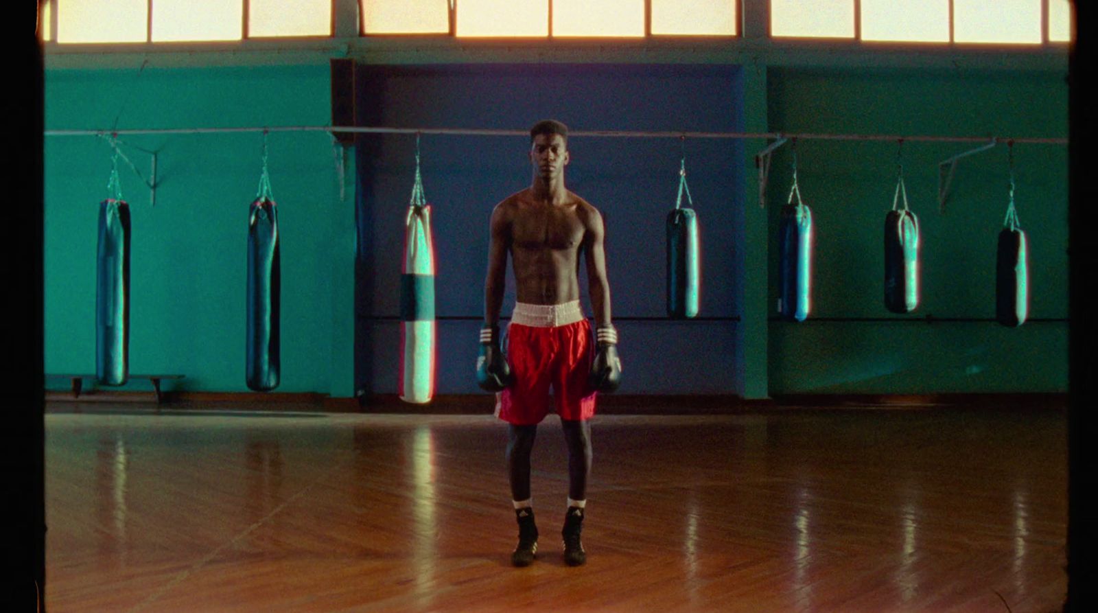 a shirtless man standing in a gym