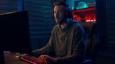 a man wearing headphones sitting in front of a computer