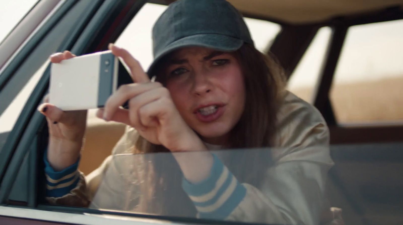 a woman taking a picture of herself in a car