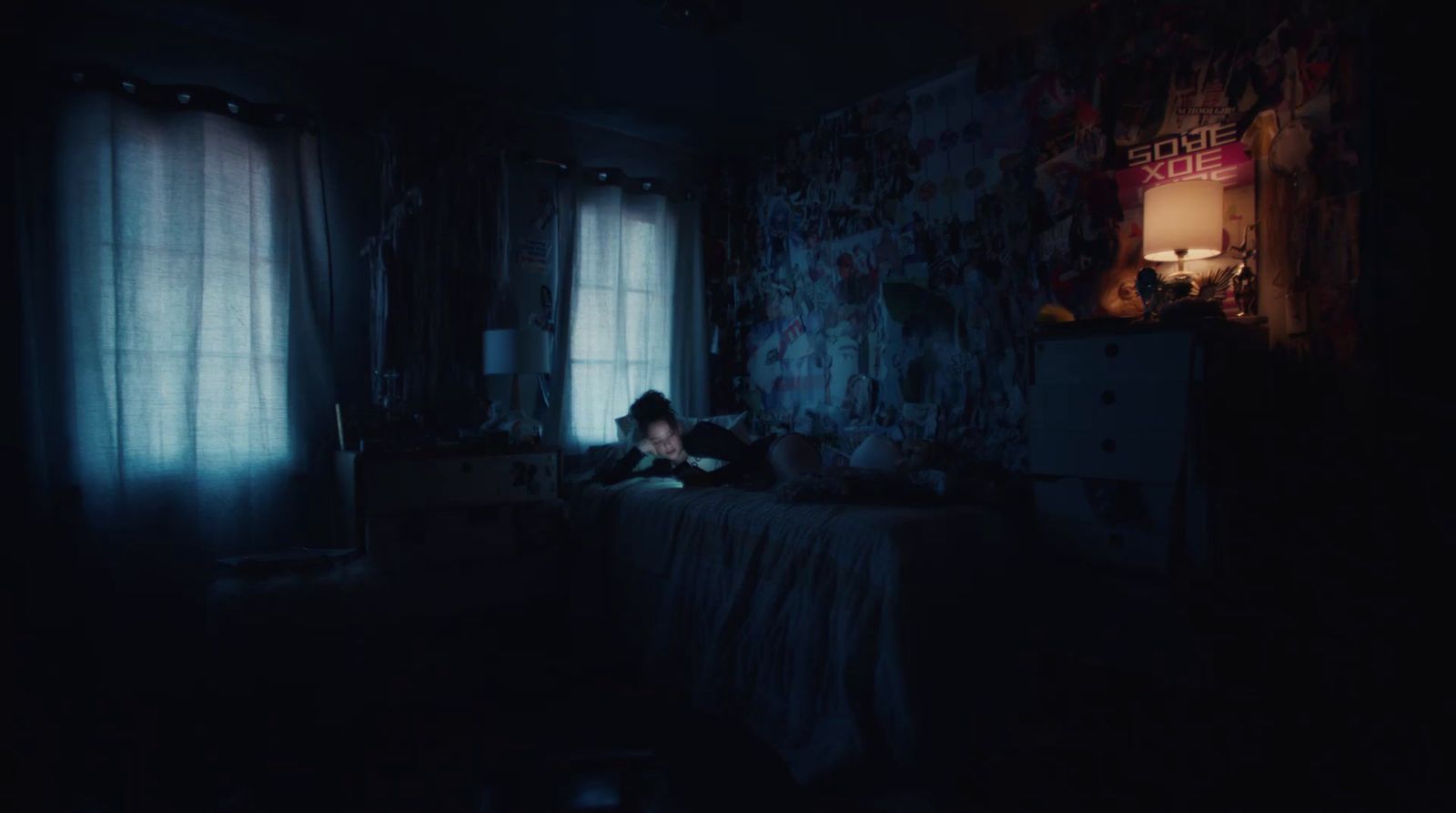 a person sitting in a dark room reading a book