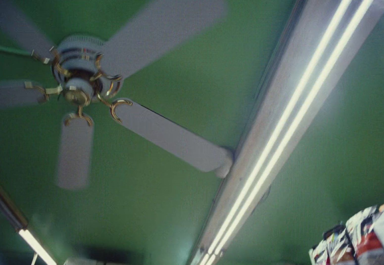 a ceiling fan in a room with green walls