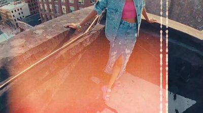 a woman standing on top of a tall building