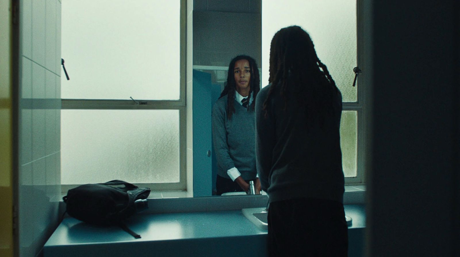 a woman standing in front of a mirror in a bathroom