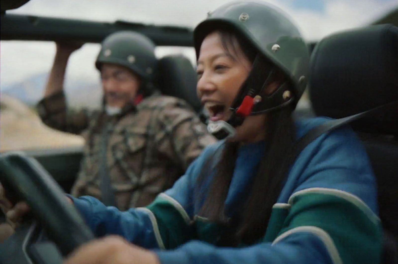 a woman driving a car with a helmet on