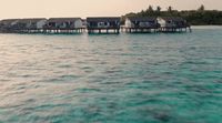 a number of houses on stilts in the water