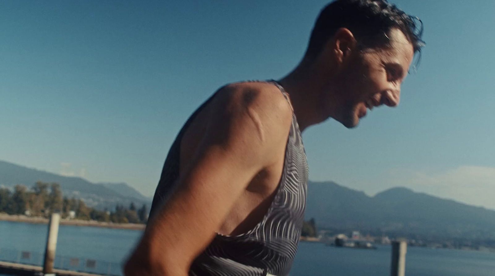 a man in a tank top holding a skateboard