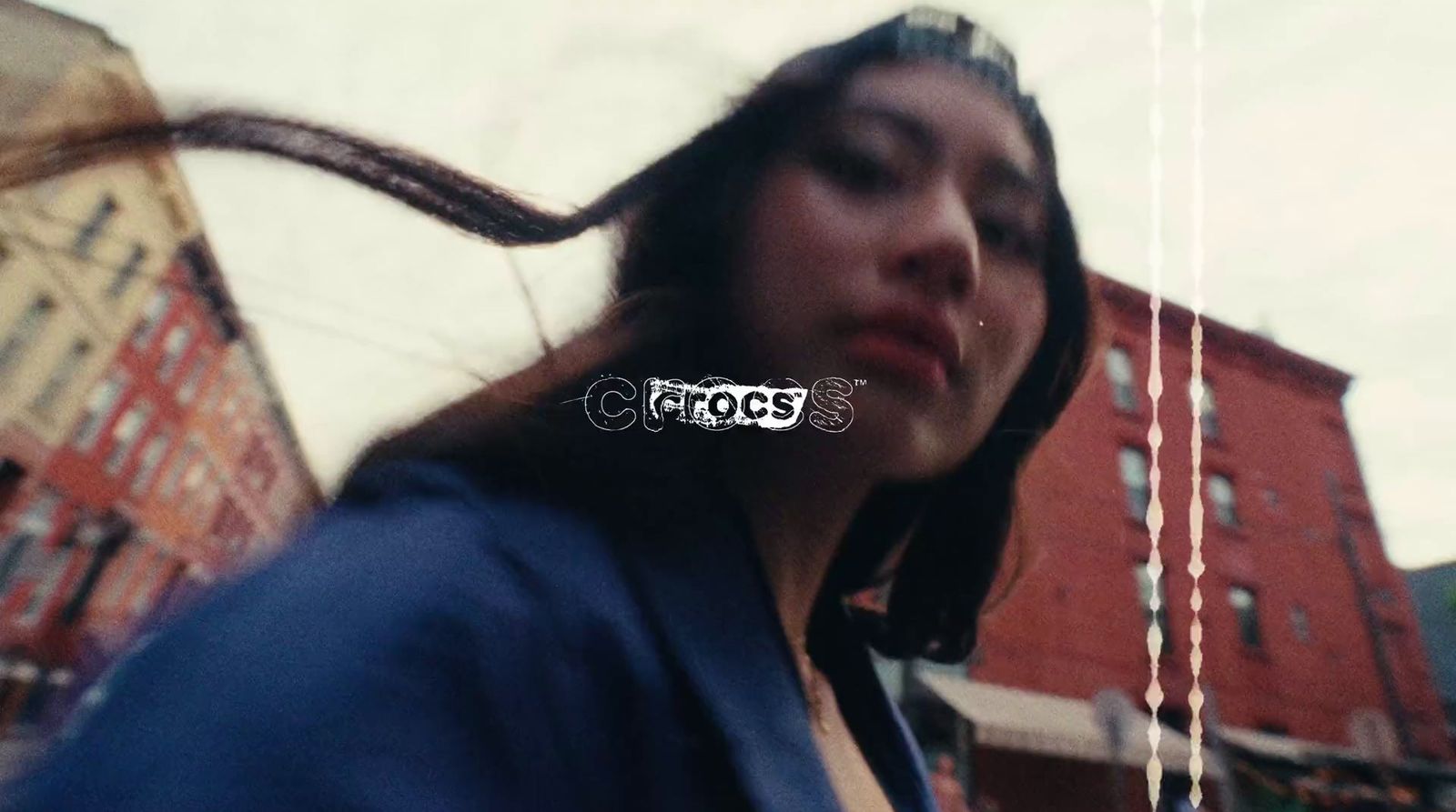 a woman with long hair standing in front of a building