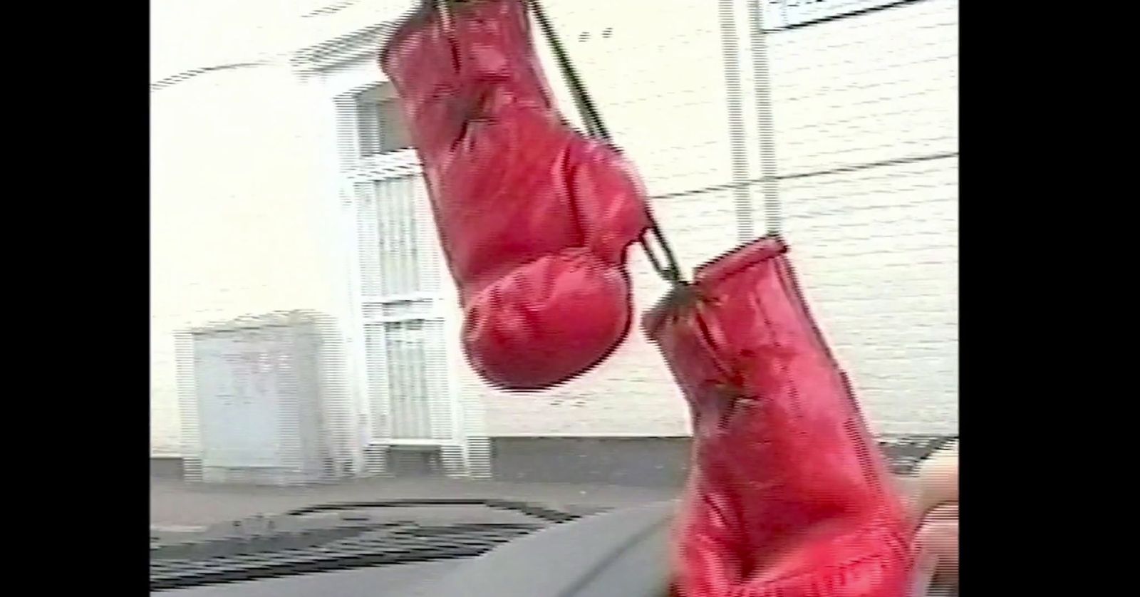 a pair of red boxing gloves hanging from a hook