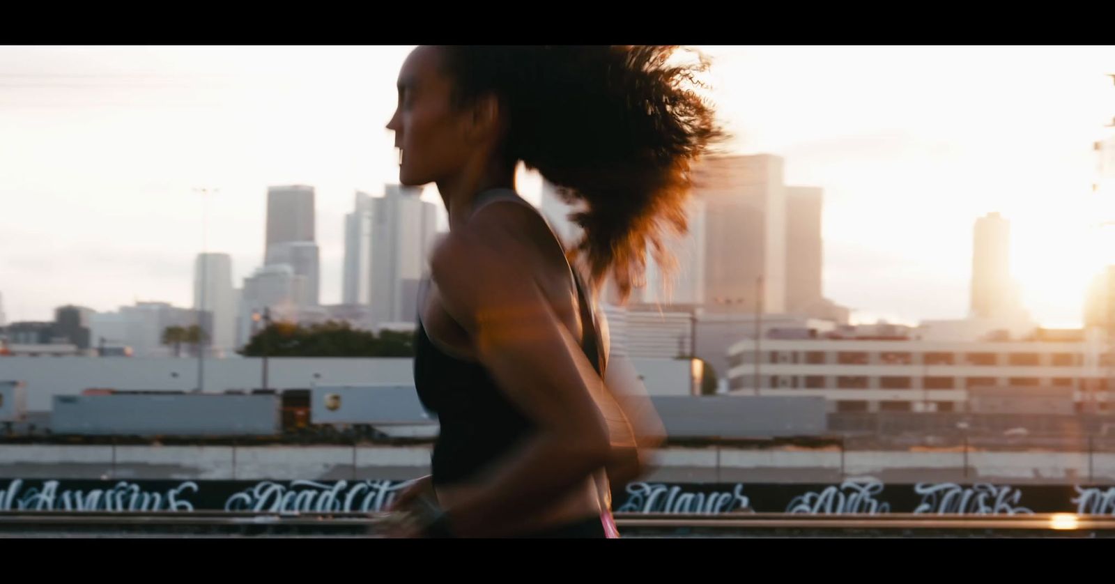 a woman running in front of a city skyline