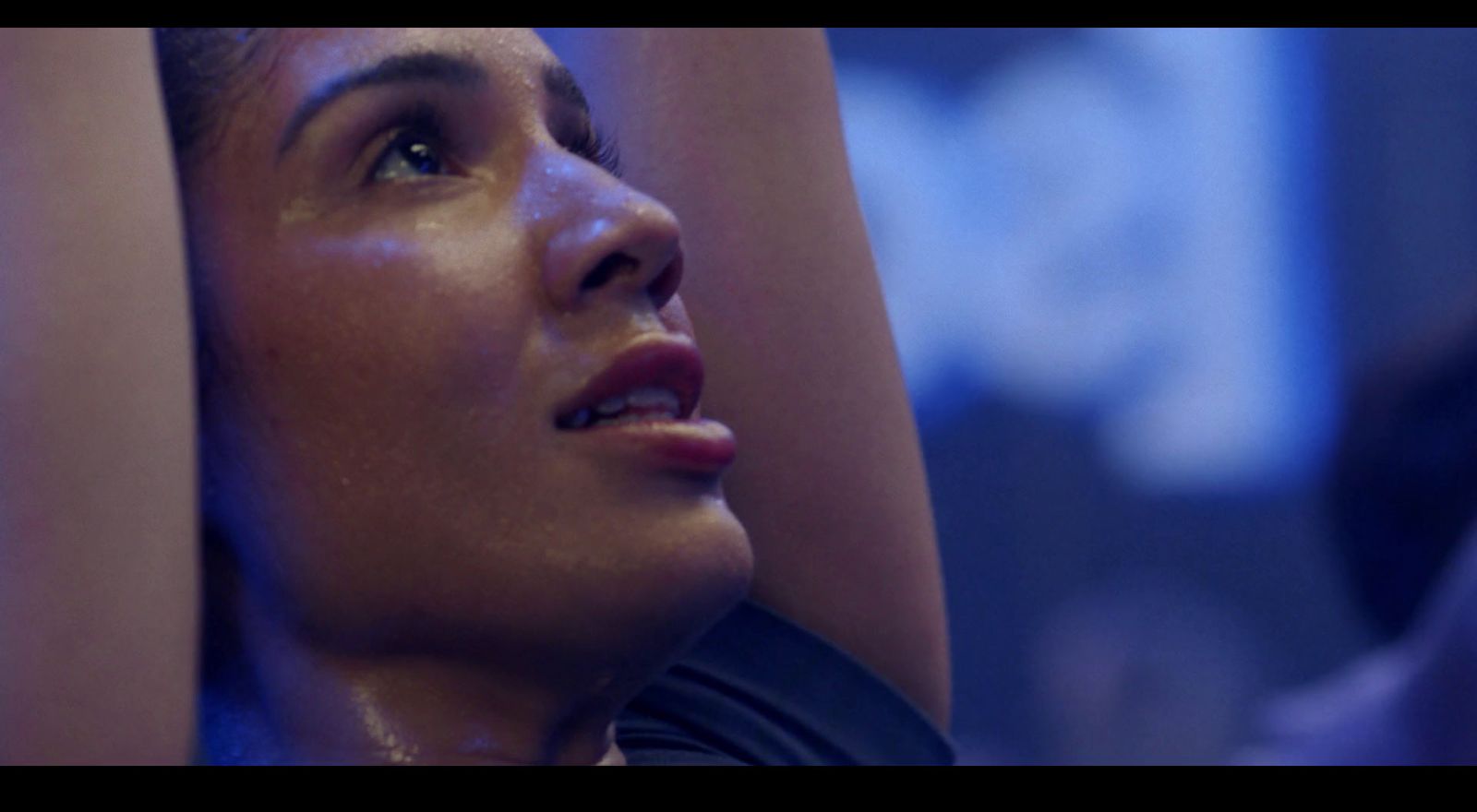 a close up of a woman with her hands behind her head