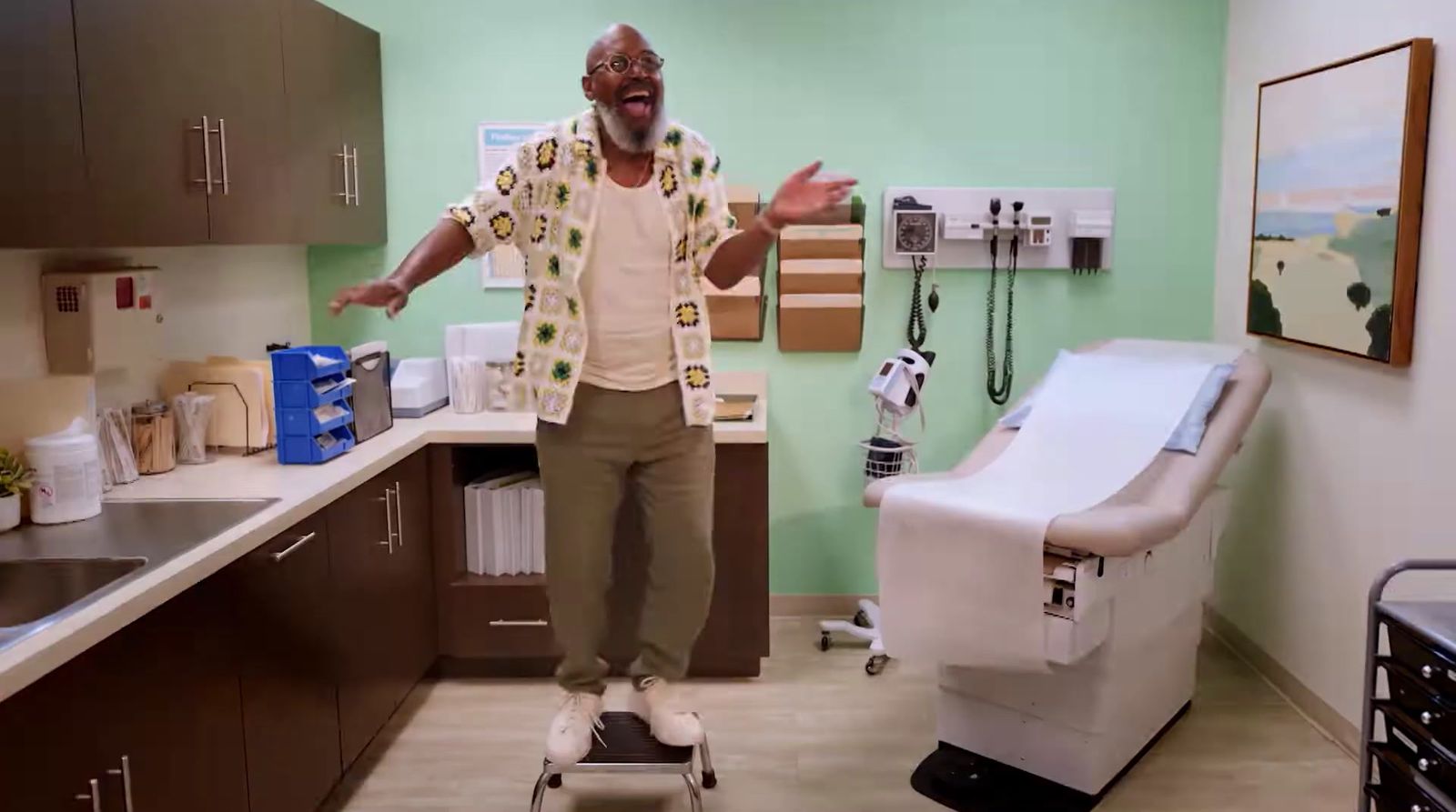 a man standing in a kitchen next to a hospital bed