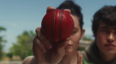 a man holding a red ball in front of his face