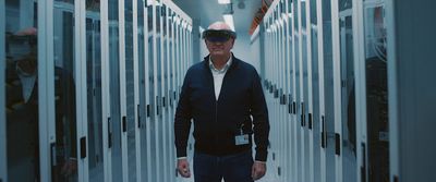 a man standing in a hallway wearing a hard hat