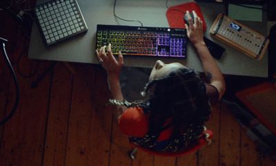 a person sitting at a desk with a keyboard and mouse