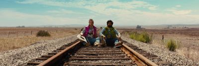 a couple of people sitting on a train track