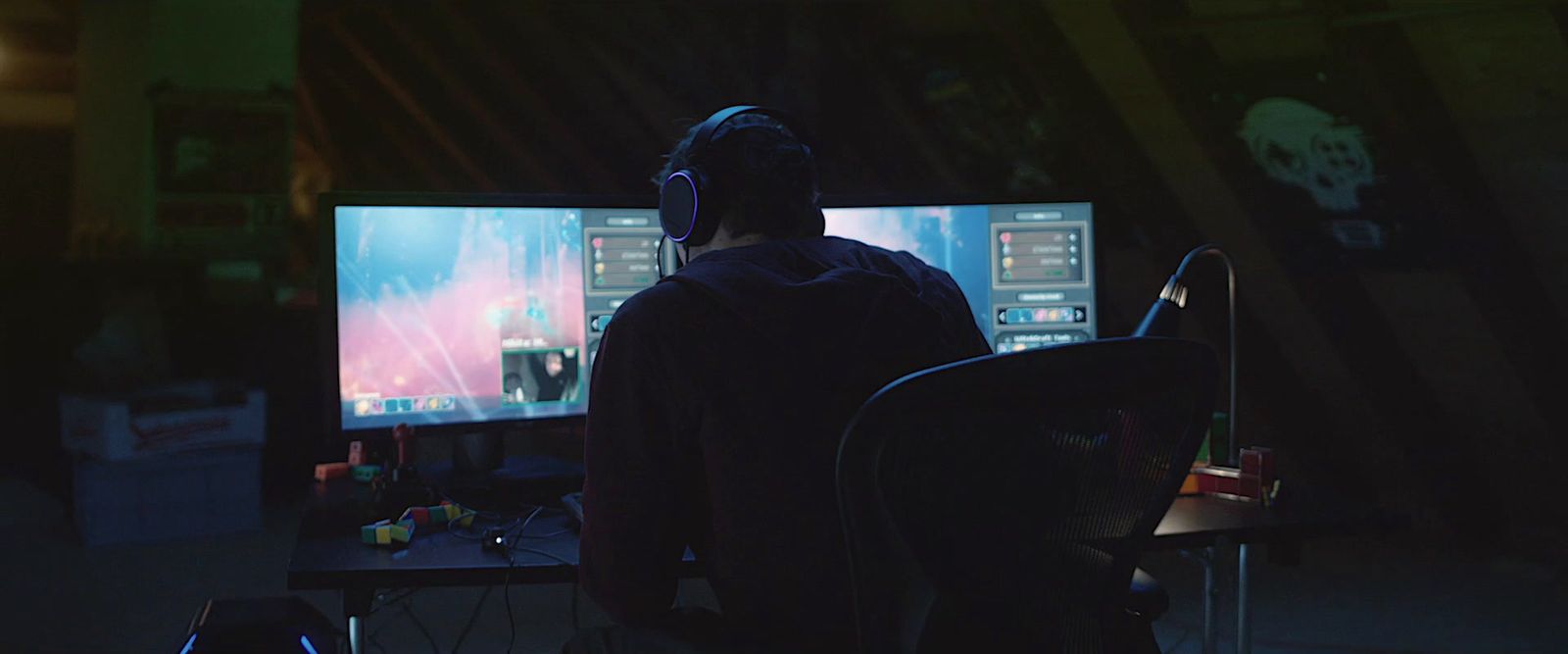 a man sitting in front of two computer monitors